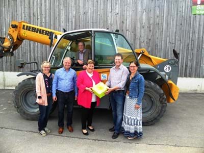 Besuch der Firma Kölbl in Apfeldorf Landrätin Andrea Jochner-Weiß überreicht an den Firmenchef der Firma Kölbl ein Präsent. Auf dem Bild auch Wirtschaftsreferent Martin Weidehass und Mitglieder der Familie Kölbl