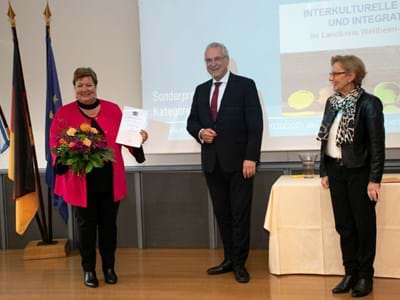 Landrätin Andrea Jochner-Weiß empfängt den Preis aus der Hand von Innenminister Joachim Herrmann (rechts Regierungspräsidentin Maria Els)