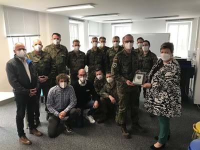 Verabschiedung der Bundeswehr-Amtshilfe: Hauptmann Endres (4.v.r.) überreicht Landrätin Andrea Jochner-Weiß (r.) die Plakette des IT-Bataillons 293 Murnau. Mit im Bild (v.li): Stefan Laubenbacher von der Personalabteilung im Landratsamt, Benedikt Wiedemann und Florian Seidler von der Sondereinheit Corona (vorne, knieend) sowie die Kameraden der Bundeswehr